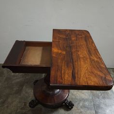 a wooden table with two trays on it's legs and one is empty