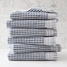 stack of blue and white towels in front of a marble tile backsplash photo