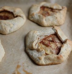 four small pastries sitting on top of a baking sheet