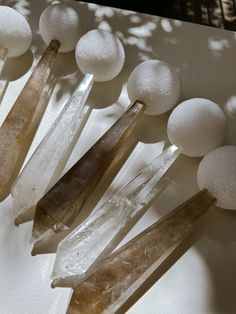 several crystals and snowballs on a white surface with shadows from the sun behind them