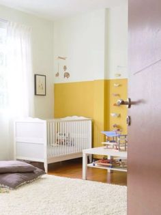 a baby's room with a white crib and yellow accent wall behind it