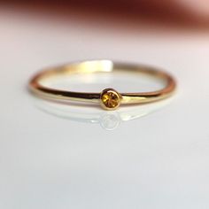 Perfect as a stacker or standing on its own, our Citrine ring is just the cutest! - Bezel set golden citrine measures 2mm across.  - Round band measures 1.1mm - Available in solid 10K or 14K Gold Looks great as a stacking ring, or a midi ring.  Processing times -  Current processing time is 2 - 4 weeks.  Each Item is handmade to order with love and care! In Stock Items -  Contact Liesel Love with any rush order questions, or to see if we have anything ready made and in stock.  Returns -  Liesel Tiny Diamond Ring, Birthstone Promise Rings, Push Present, November Birthstone Ring, Promise Ring For Her, Zierlicher Ring, Bezel Ring, Promise Rings For Her, Tiny Diamond