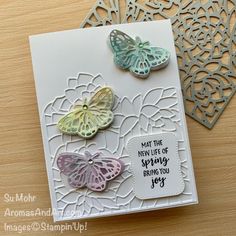 a close up of a card with butterflies on it and a doily pattern in the background