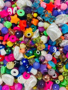 many different colored beads are scattered on top of each other in this image, there is a large amount of them