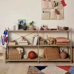 a book shelf filled with lots of books and other items next to a wall hanging