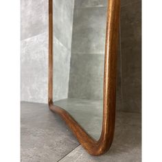 a wooden mirror sitting on top of a tiled floor