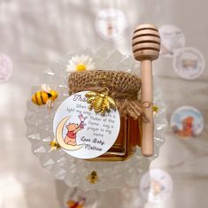 a honey jar with a wooden stick and some bees around it