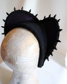 This is a purple and black version of one of most successful designs called Countess. This vampire style headdress is covered with dark purple taffeta and embellished with black cord trimming all around the edges.It is further trimmed with black crystal details that create a halo effect as well as small l beads that were hand-sewn on the trimming to create rich textural interest. The piece is completed with a black crystal handmade element placed at the center front for all that extra drama that Black Medieval Costume Accessories For Cosplay, Medieval Black Costume Accessories For Cosplay, Witchy Black Costume Hats For Cosplay, Black Medieval Costume Accessories For Parties, Black Medieval Costume Accessories For Costume Party, Black Fantasy Costume Accessories For Theater, Medieval Costume Hats And Headpieces For Halloween, Black Fantasy Costume Accessories For Carnival, Black Fantasy Costume Accessories For Costume Party