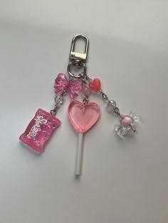 a pink heart shaped lollipop with a candy bar on it's side