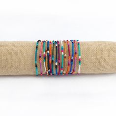 These fair trade Round Silk Friendship Bracelets are handwoven by Guatemalan artisans so each one is unique! The bracelets measure 14" L x .125" W and feature a tie closure. Color combinations and patterns vary. Available in multi color or rainbow. Each purchase empowers Guatemalan artisans. Adjustable Multicolor Artisan Wrap Bracelet, Multicolor Braided Bangle Bracelet, Multicolor Braided Bracelet Bangle, Multicolor Braided Bead Bangle Bracelet, Artisan Beaded Multicolor Wrap Bracelet, Artisan Multicolor Beaded Wrap Bracelet, Adjustable Handwoven Friendship Beaded Bracelets, Artisan Fair Trade Beaded Bracelets For Gifts, Adjustable Fair Trade Beaded Bracelets For Friendship