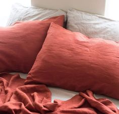 a bed with two red pillows on top of it