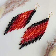 These long beaded earrings feature a black-and-red color scheme with a diagonal gradient. Handmade with meticulous attention to detail, they exude sophistication and elegance. Perfect for completing your ensemble with chic and style. Dimensions: - Length: 10 cm (3.9 inches) - Width: 3 cm (1.2 inches) Bohemian Black Teardrop Beaded Earrings, Red And Black Beaded Festival Earrings, Red And Black Beaded Earrings For Festival, Adjustable Red Beaded Earrings With Black Beads, Traditional Red Earrings With Black Beads, Red And Black Beaded Drop Earrings, Red Teardrop Beaded Earrings For Festival, Red Bohemian Teardrop Beaded Earrings, Festival Black Beaded Chandelier Earrings