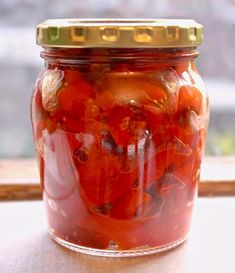 a jar filled with pickles sitting on top of a window sill