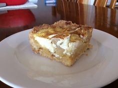 a piece of dessert sitting on top of a white plate next to a wooden table