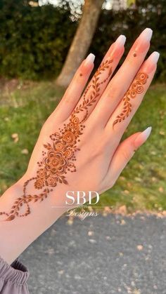 a woman's hand with henna tattoos on it