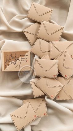 several envelopes are laid out on a white sheet and some have stitched in to them