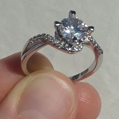 a person holding a ring with a diamond in it