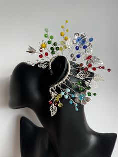 a black mannequin headpiece with multicolored beads and leaves on it