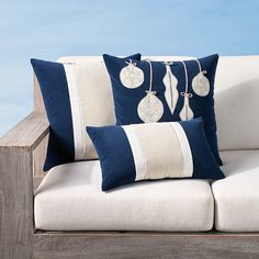 two blue and white pillows sitting on top of a couch