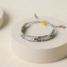 two bracelets sitting on top of a white box