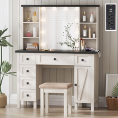 a white desk with drawers and a stool in front of it, next to a potted plant