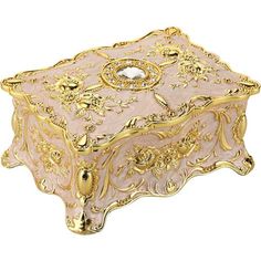 a pink and gold box sitting on top of a white surface with an ornate design