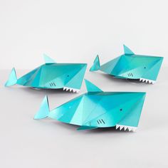 three origami shark sculptures on white background