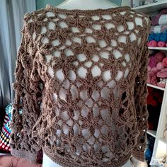 a crocheted sweater is shown on a mannequin