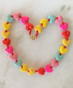 "Kids Brite Multi Colored Plastic Heart Necklace with Red Mini Spacer Beads Gold Tone Spring Ring Clasp Closure Brite Multi Hearts are Red, Hot Pink, Pink, Aqua, Yellow Hearts Measure 5/8\" Wide Necklace Measures 15\" Imported COMPLIMENTARY DOMESTIC SHIPPING" Valentine's Day Jewelry With Heart-shaped Beads, Valentine's Day Jewelry With Heart Beads, Valentine's Day Playful Beaded Jewelry, Valentine's Day Beaded Necklaces For Jewelry Making, Adjustable Heart Beads Necklace For Valentine's Day, Beaded Heart Necklace For Valentine's Day, Multicolor Heart Beads Round Jewelry, Playful Round Beads Jewelry For Valentine's Day, Multicolor Heart Necklace For Valentine's Day Gift