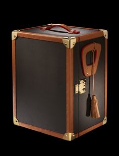 an old suitcase with a handle and tassel on the inside is shown in front of a black background