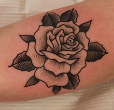 a black and white rose tattoo on the arm