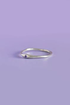 The Siyum gem ring is a true minimalist piece, a fine seamless round band is hand brushed finished allowing a contemporary aesthetic. Perfect for everyday, once you take it off you won't take it off! A petite round White Sapphire adds a beautiful detail and personalised touch. Use the drop down to select your ring size.If you are unsure of your ring size refer to our size guide. Please select your ring size carefully, and reach out if you have any questions. DetailsSterling Silver Handcrafted in Everyday Jewelry With Tension Setting In Round Band, Minimalist Open Ring Stackable Birthstone Rings, Minimalist Stackable Rings With Tension Setting, Minimalist Adjustable Birthstone Promise Ring, Minimalist Everyday Birthstone Ring, Minimalist Birthstone Ring With Tension Setting, Minimalist Birthstone Ring With Round Band For Promise, Minimalist Hammered Midi Rings As Gift, Minimalist Birthstone Midi Rings For Everyday