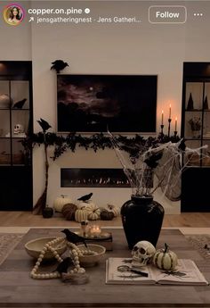 a living room decorated for halloween with candles and decorations on the coffee table in front of it