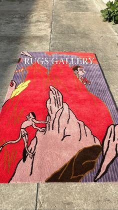 the rug is on the sidewalk and has an image of a man climbing up a mountain