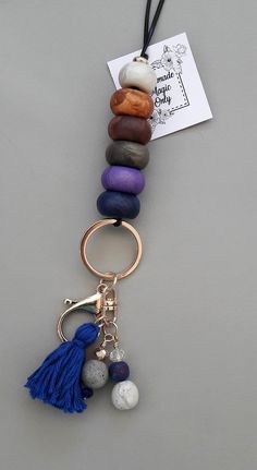 a stack of rocks with a tassel hanging from it's end on a key chain