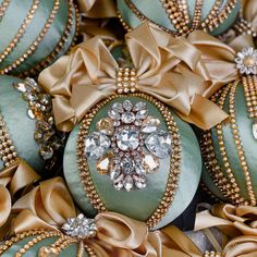 many green ornaments with gold bows and jewels on them are arranged in the shape of an ornament