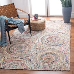 a living room area with a chair, rug and potted plant