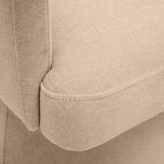 the back end of a beige couch with buttons on it's armrests