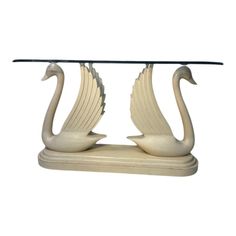 a glass table with two swans on it