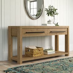 a wooden console table sitting on top of a hard wood floor next to a mirror