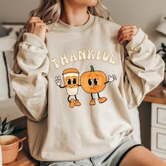 Thanksgiving "Thankful" Unisex Crewneck Sweatshirt Made on a High Quality Gildan 18000 The collar is ribbed knit, so it retains its shape even after washing. There are no itchy side seams on these sweaters.  Made with a medium-heavy fabric blend of 50% cotton and 50% polyester (8.0 oz/yd² (271.25 g/m this sweatshirt feels cozy and is the perfect choice for those colder months. The classic fit along with the crew neckline deliver a comfy wearing experience with a clean-cut style. Meanwhile, the d Cute Fall Sweater, Thankful Sweatshirt, Cute Sweaters For Fall, Thanksgiving Sweatshirt, Sweatshirt Cute, Fall Sweater, Thanksgiving Gift, Clean Cut, Thanksgiving Gifts