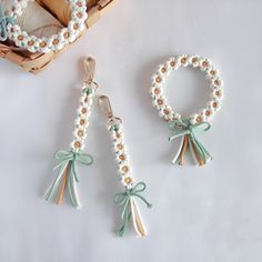 two pieces of beaded jewelry with bows and beads hanging from it's sides