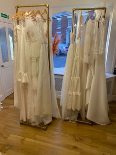 several dresses are on display in front of a window with a view of the street