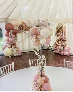 a table topped with lots of balloons and flowers