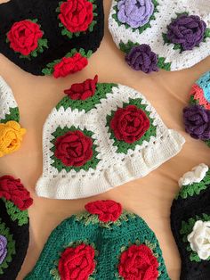 several crocheted hats with flowers on them