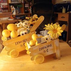 a wooden cart filled with lemons on top of a table