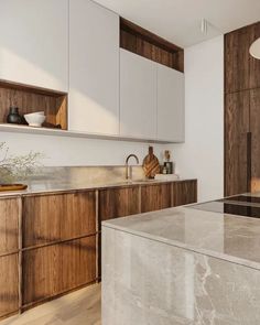 a kitchen with marble counter tops and wooden cabinets