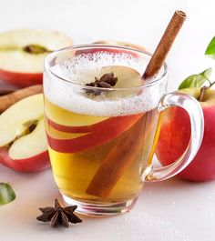 an apple cider with cinnamon and apples in the background