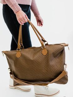 Did someone say must-have bag? The Olivia weekender is an absolute essential in every woman's closet. The timeless patterns, buttery smooth vegan leather, and versatile straps make it a top contender for the title of the perfect bag.Great for travel, carry-on duffle bag, vacation, overnight, extended weekend getawaysand day trips. Details: The Olivia is 26" wide x 15" long x 7" deep detachable strap adjusts to be up to 42" long Gold hardware 3 interior pockets, including 1 with a zipper Dark Tan Tote Bag For Travel, Caramel Shoulder Bag For Travel, Dark Tan Travel Bag With Double Handle, Fall Travel Bag In Camel Color, Brown Shoulder Duffle Bag For Everyday Use, Dark Tan Double Handle Travel Bag, Brown Rectangular Travel Bag With Adjustable Strap, Brown Travel Bag With Adjustable Strap For Everyday, Dark Tan Travel Shoulder Bag