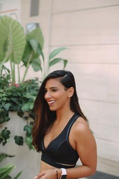 a woman in a black sports bra smiling at the camera